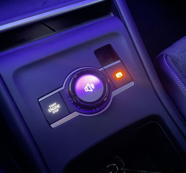 Botón multifunción entre los asientos. Controla el equipo de sonido y/o el modo de conducción. 